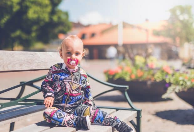 toddler sitting on wooden bench